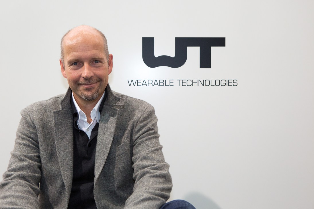 Christian Stammel, CEO of Wearable Technologies, poses next to the company logo at Medica trade fair