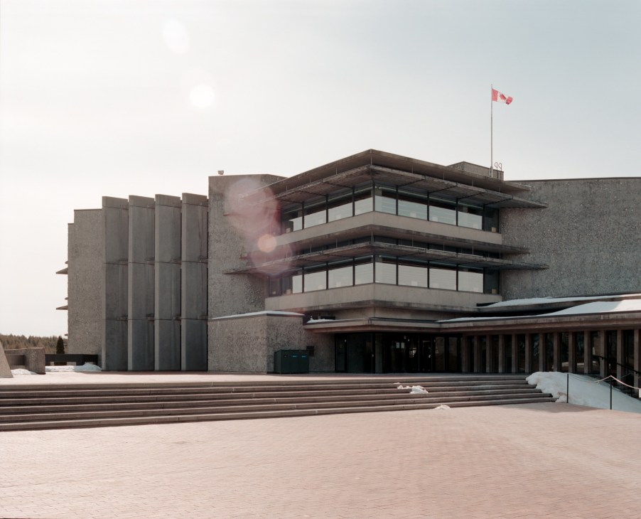 Brutalist concrete facade of Bata Library at Trent University with vertical bastions and large windows, Canadian flag visible on roof.