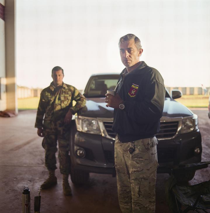 Captain Oscar Chamorro, head of Senad's special forces, stands at the base in camouflage uniform holding mate.