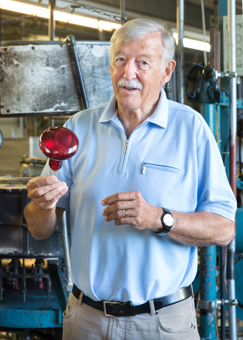 Hans Borner, owner of Righi Licht, holds a red incandescent bulb in his factory.