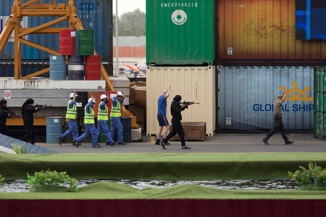 Armed personnel and workers simulate a hostage rescue scenario at a container port during Idex opening ceremony.