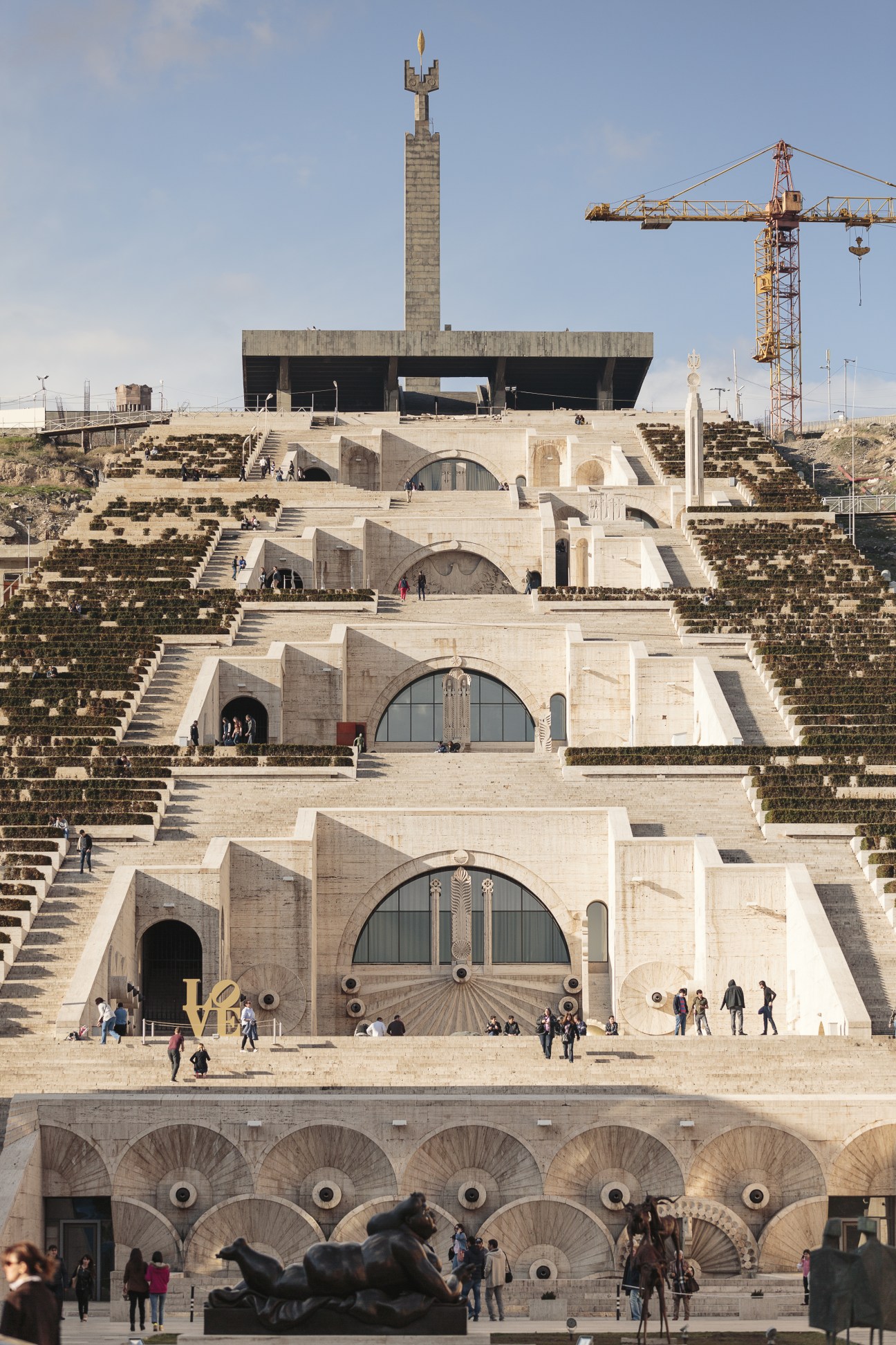 Cafesjian Center for the Arts in Yerevan with tiered stone steps, arched entrances and Mother Armenia monument above.