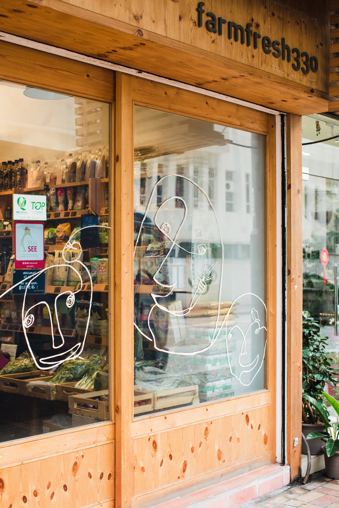 Farm Fresh 330 storefront with wooden facade and neon vegetable signage in Hong Kong.