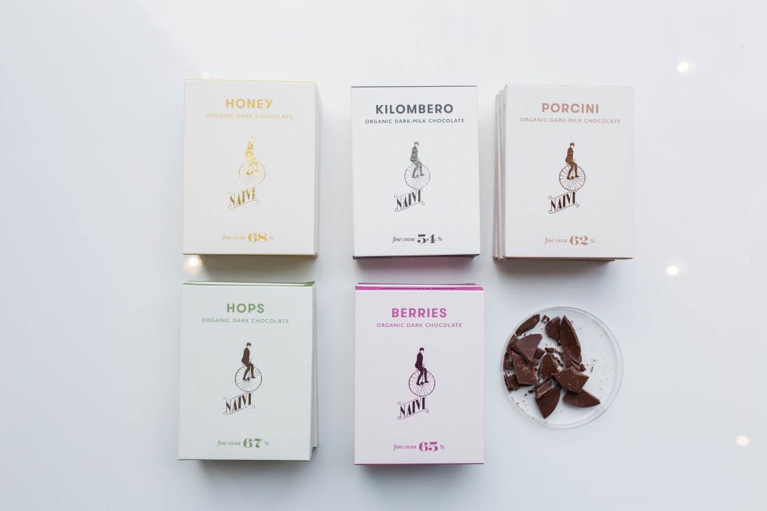 House of Naïve organic chocolate bars displayed in white packaging with flavor names and cocoa percentages.