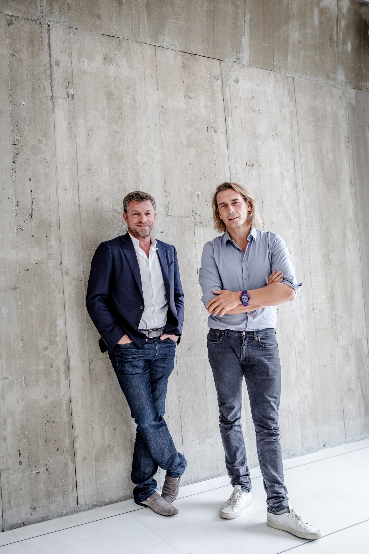 Two men standing against a concrete wall, Jacques Bungert and Frédéric Torloting, owners of Courrèges fashion brand.