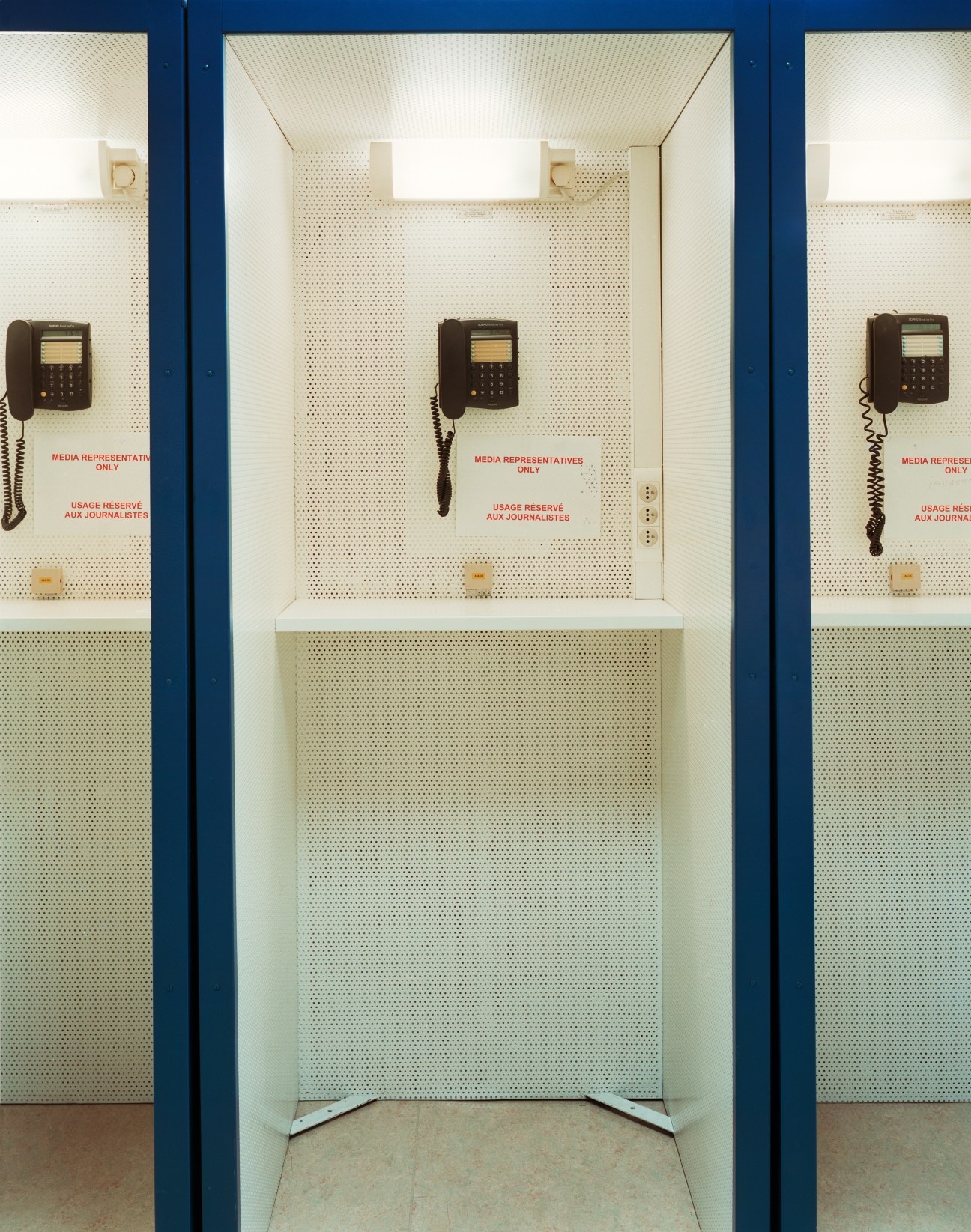 Three vintage phone booths with rotary phones and perforated panels, marked for media representatives only.