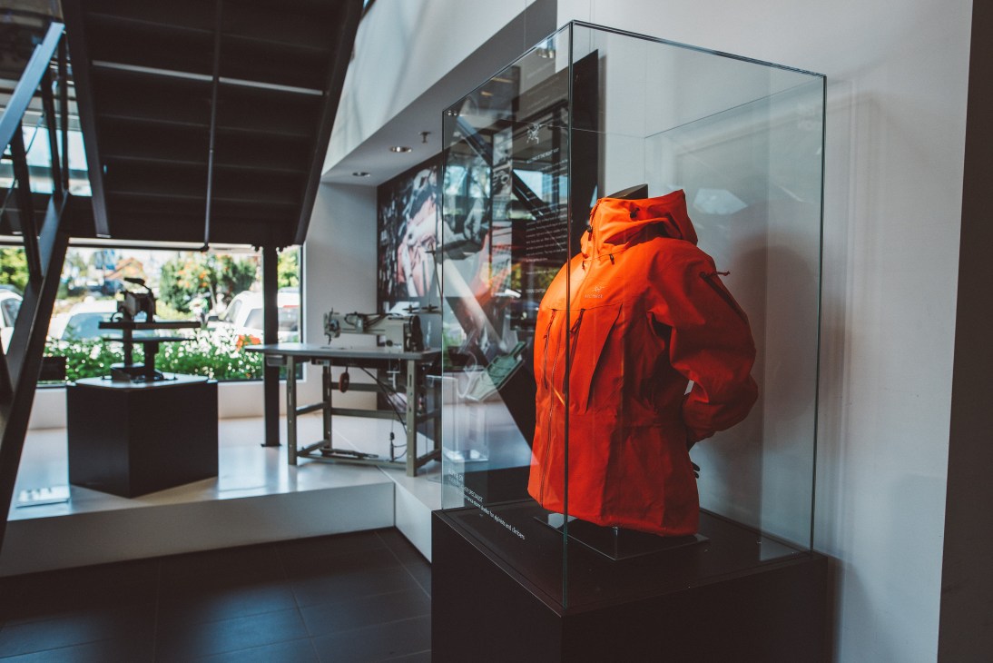 Arc'teryx red outdoor jacket displayed in a glass case at the brand's Vancouver studio.