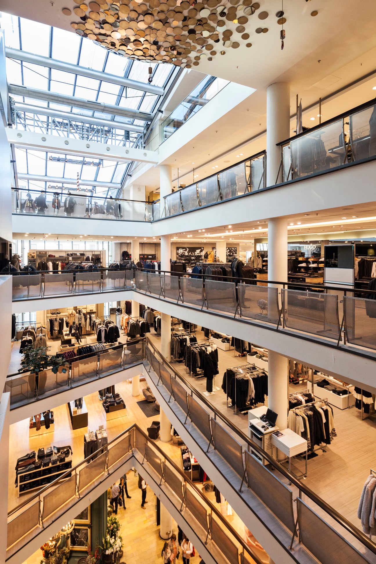 Interior view of Engelhorn's Mode im Quadrat building showing multiple floors of fashion displays with skylights above.
