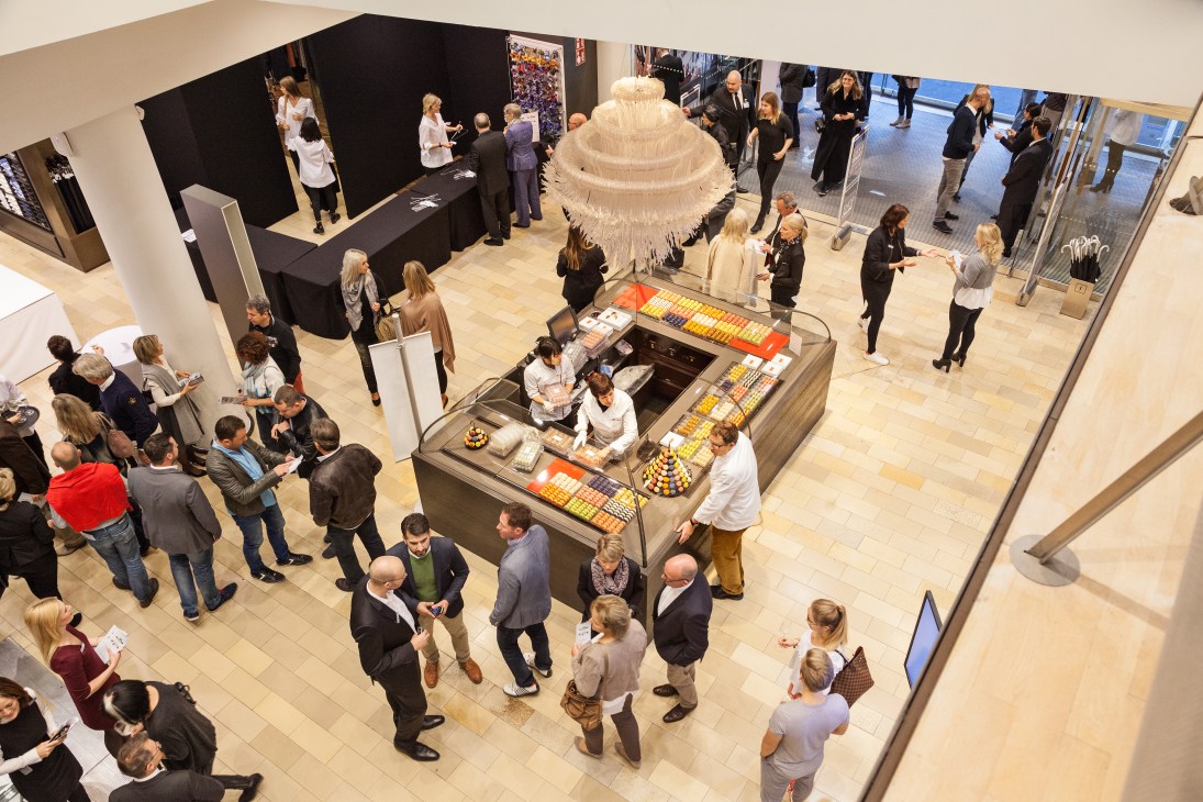 Overhead view of Engelhorn's Mode im Quadrat building interior with visitors browsing around a central display featuring a large decorative white chandelier.