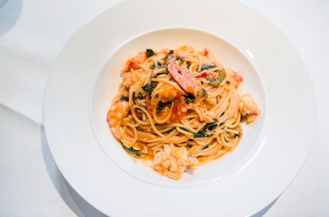 Lobster spaghetti with fresh herbs on a white plate at Cecconi's.