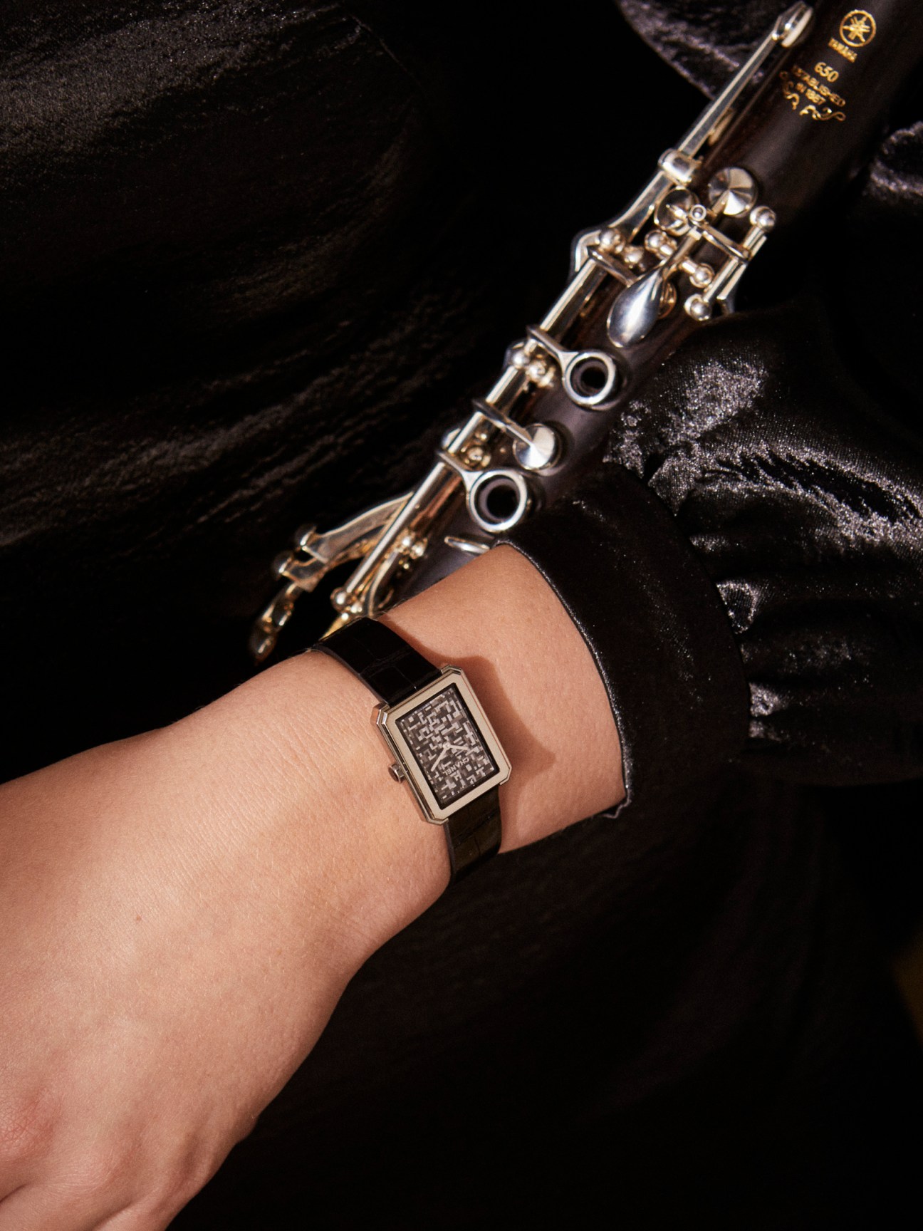 Chanel Boy.Friend Neo Tweed watch on wrist with musical instrument in background