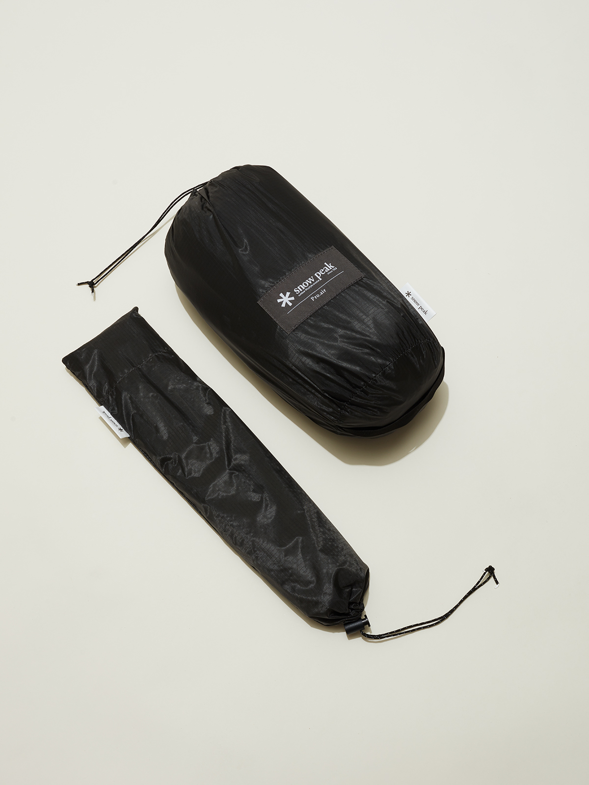 Black packaged tent components with drawstring storage bags and Snow Peak branding label
