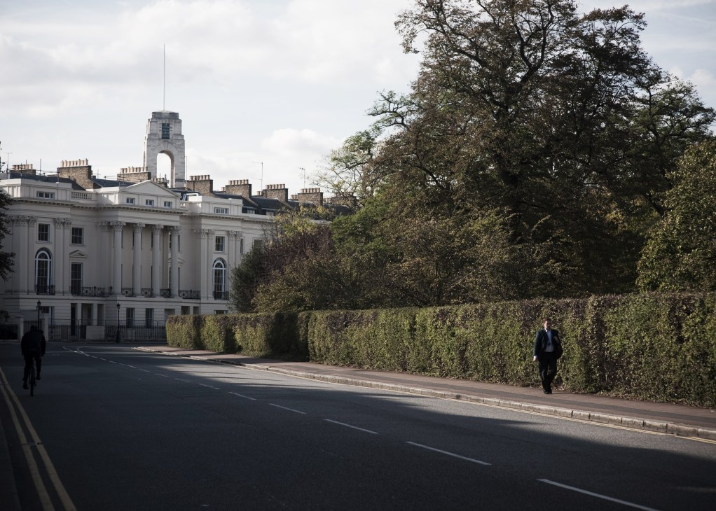 Georgian buildings with columns next to Regent's Park in London, with cyclists on the street.