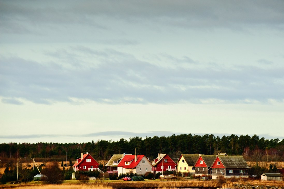 Row of traditional Estonian houses with red and white painted wooden facades on Muhu Island.