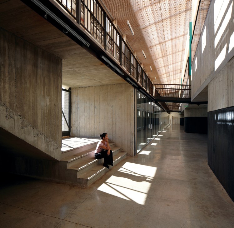 Interior of Parque Cultural de Valparaíso showing concrete architecture with natural light and a person sitting on steps.