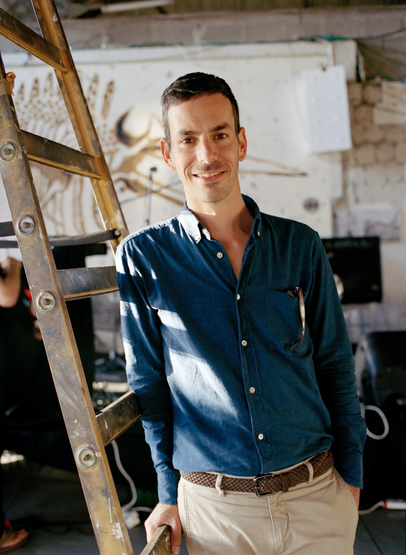 Eyal de Leeuw, 39, head of external relations of Design Museum Holon, smiling in a studio setting.