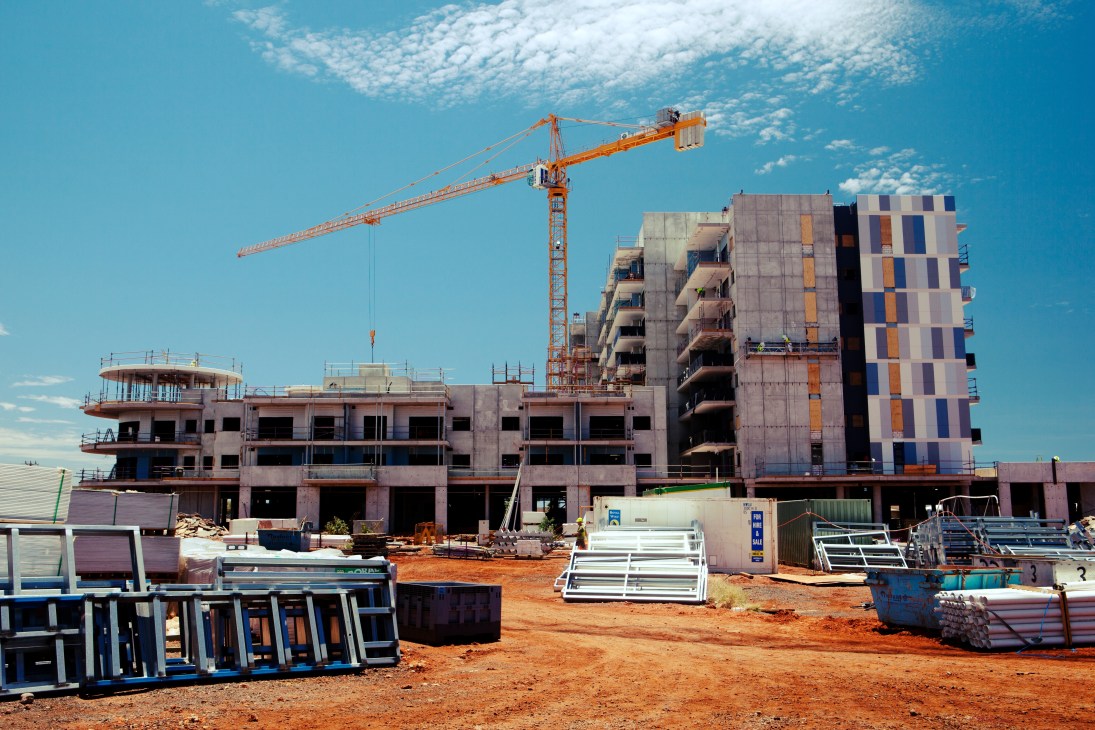 Construction site of multi-story apartment building with orange crane in Karratha, Western Australia