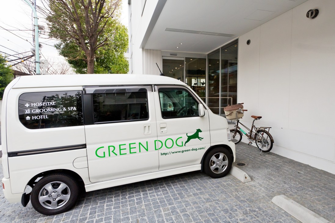 White van with Green Dog branding offering hospital, grooming, spa and hotel services for dogs in Tokyo.