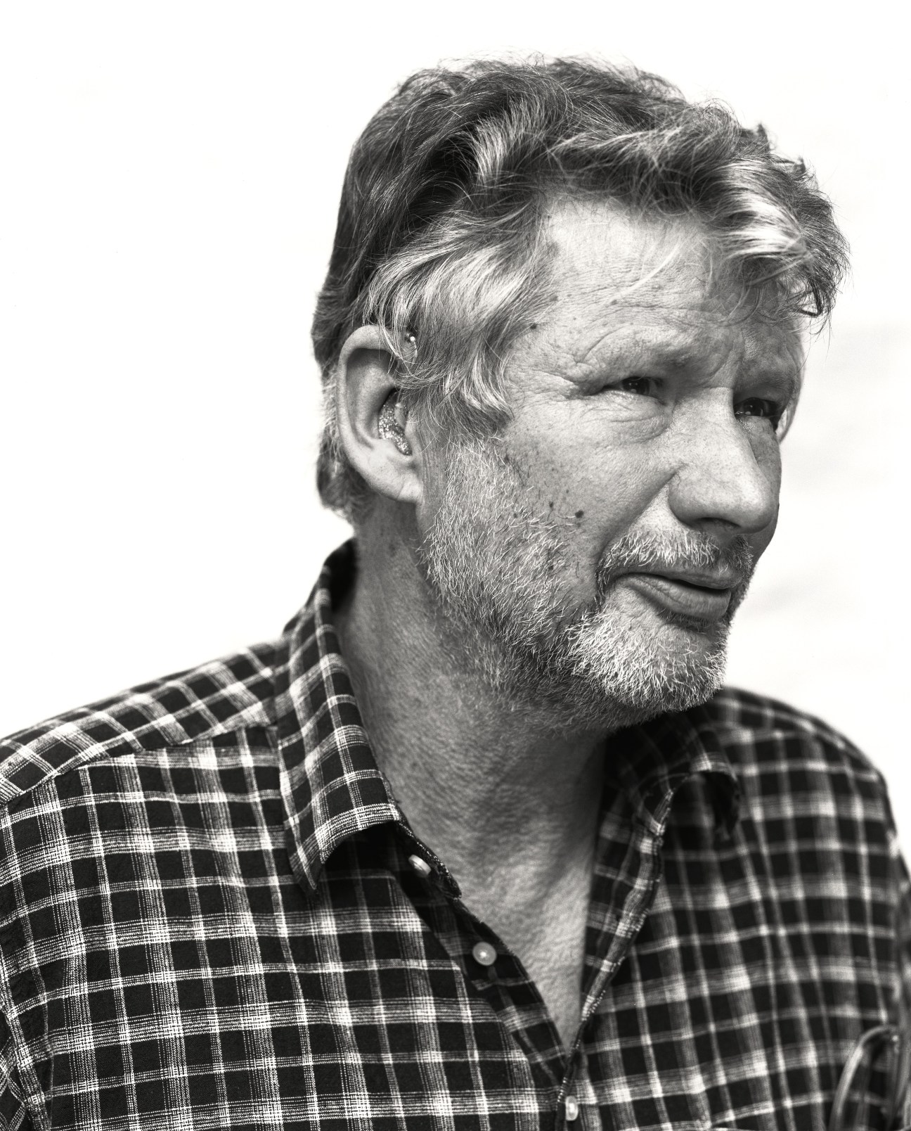 Black and white portrait of Carl-Magnus Persson, a bearded man in a plaid shirt.
