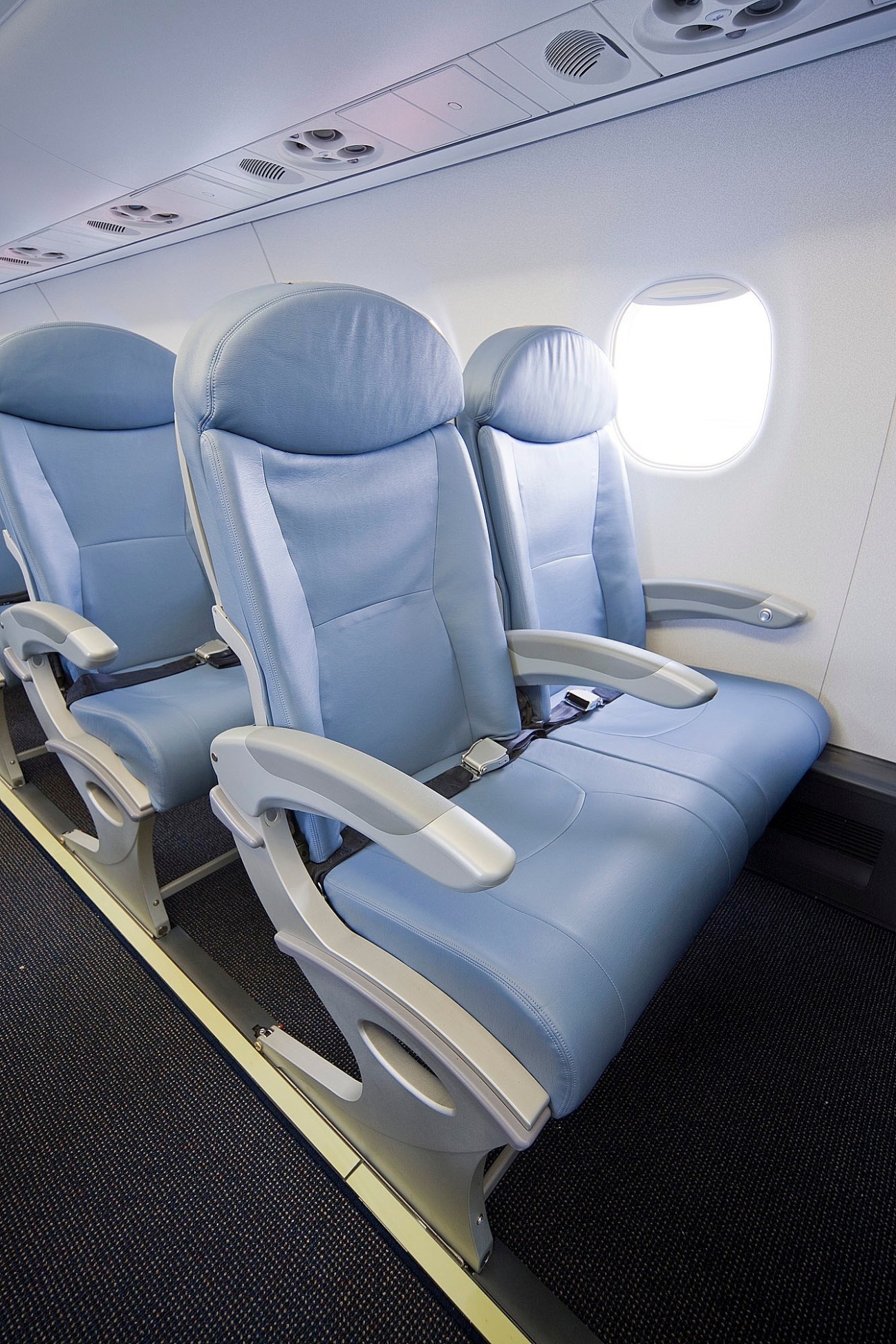 Interior of a Fuji Dream Airlines aircraft with blue and grey upholstered seats and a window.