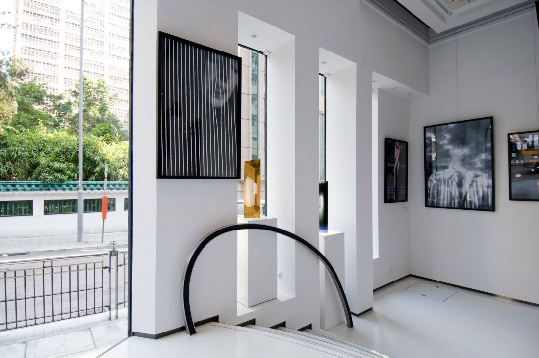 Modern art gallery interior with white walls, contemporary artworks, and sculptural installations.