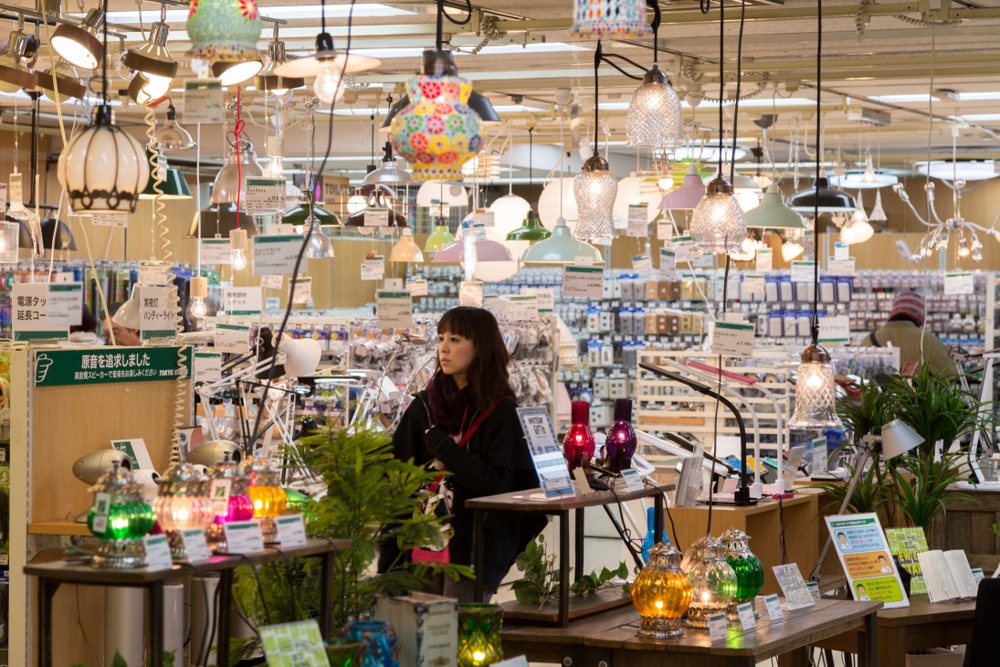 Lighting department display at Tokyu Hands with pendant lamps and decorative fixtures hanging above tables.