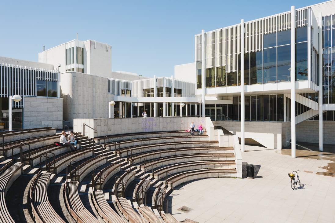 Outdoor amphitheatre in Tapiola with curved seating tiers overlooking modernist white buildings and a central plaza.