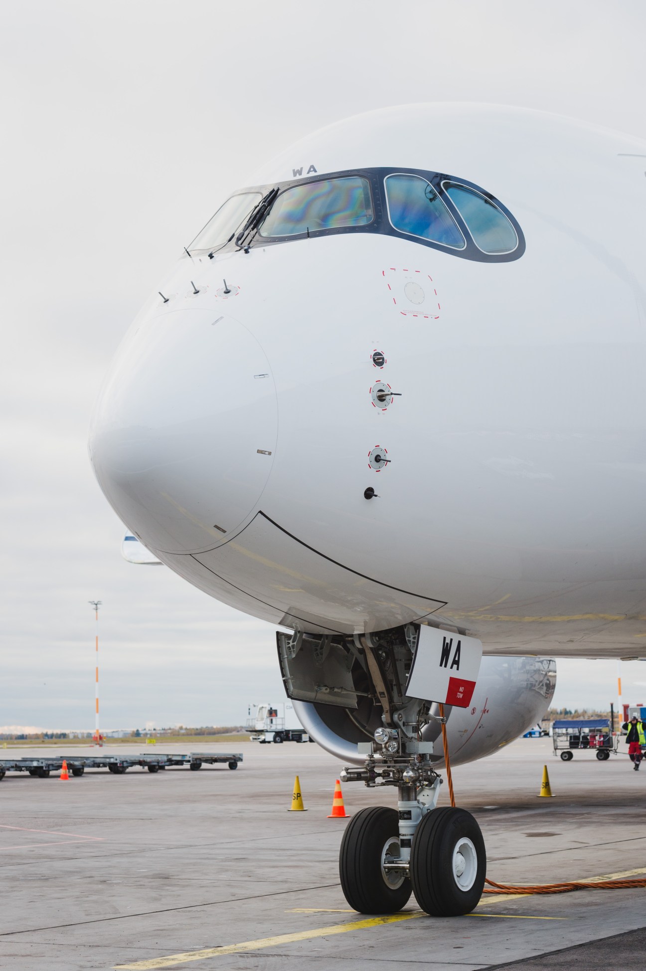 Finnair's Airbus A350 aircraft on airport tarmac with ground vehicles nearby.
