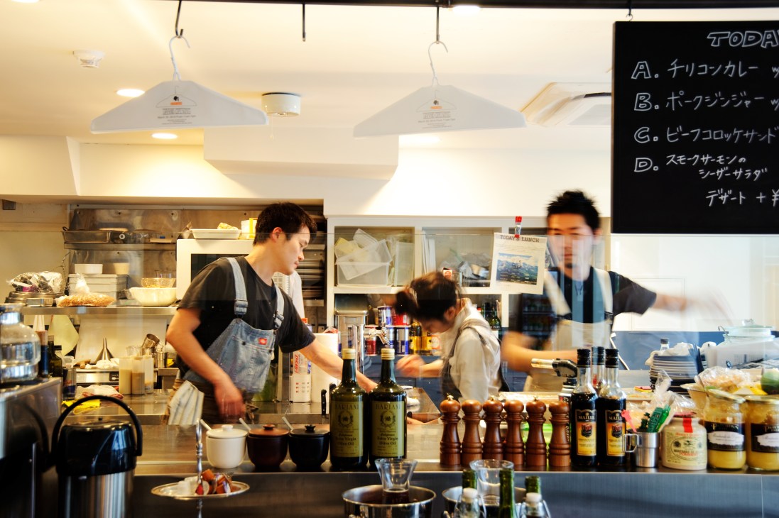 Staff prepare food and drinks behind the counter at Overall Café in the Tabloid building.