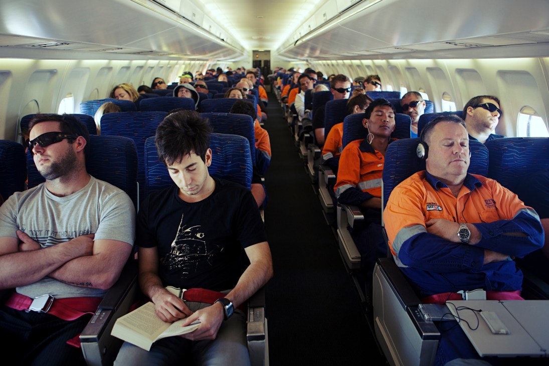FIFO workers rest and sleep aboard a charter flight from Perth to Woodie Woodie mining camp.