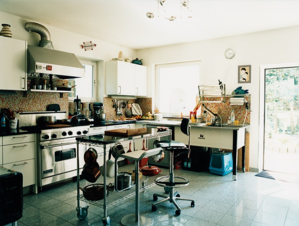 A bright, well-organized kitchen with vintage appliances, mosaic tile backsplash, and cooking equipment.