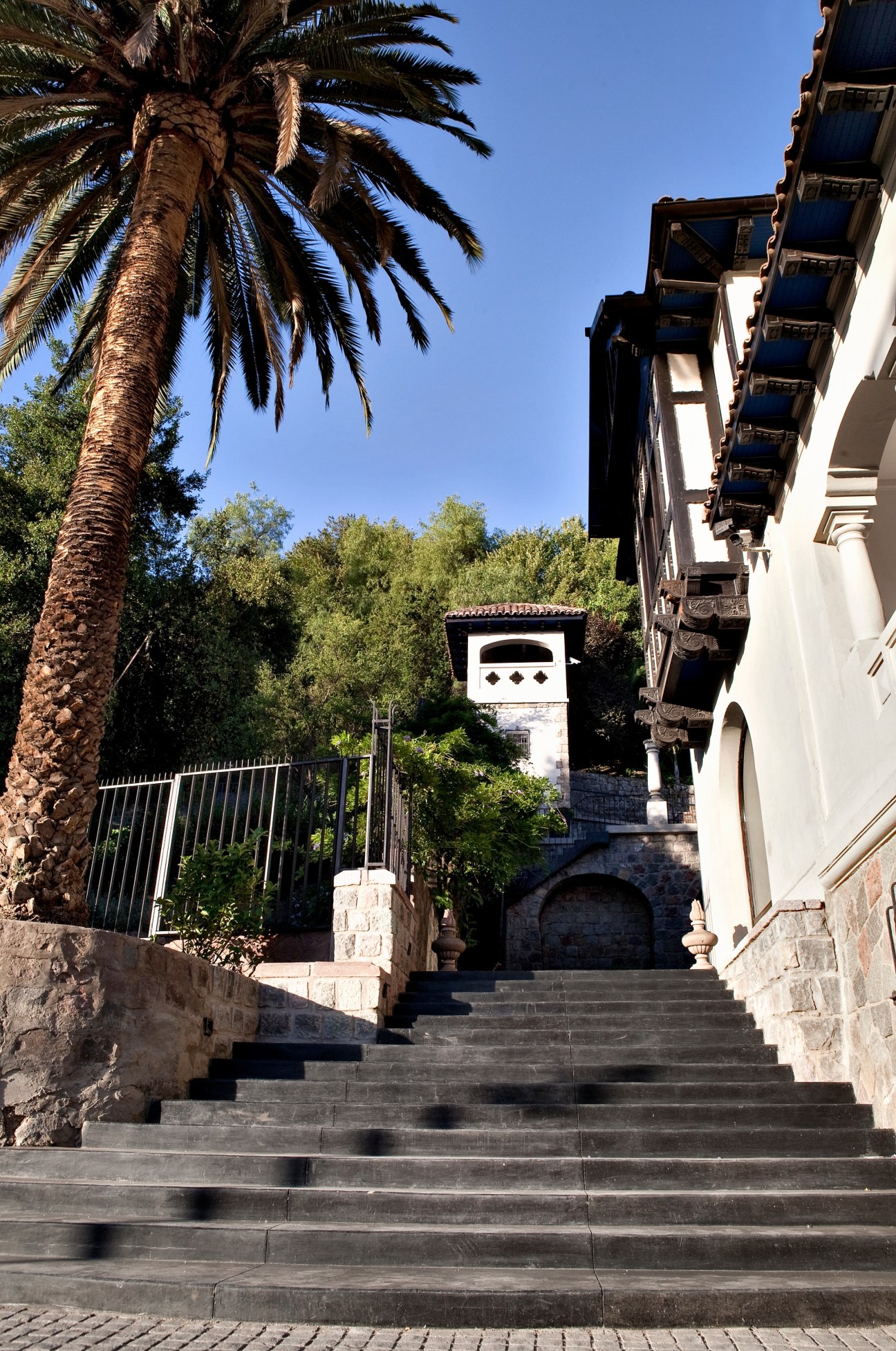 Stone steps leading up to The Aubrey hotel in Santiago with palm tree and colonial architecture.