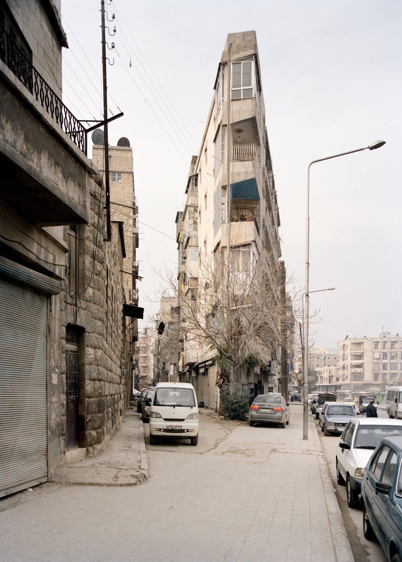 Aleppo's distinctive wedge-shaped 'Flat Iron' building in the Midan Armenian quarter, with parked cars on the street below.