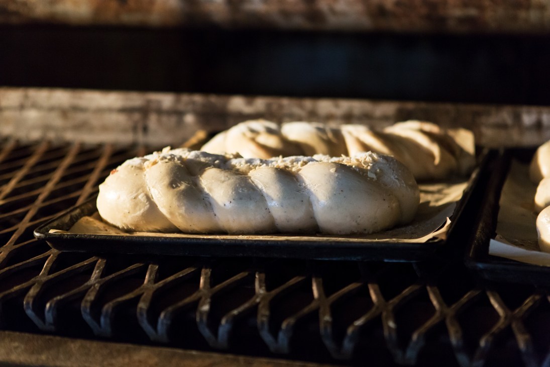 Braided Finnish sweet bun on a baking tray in an oven.