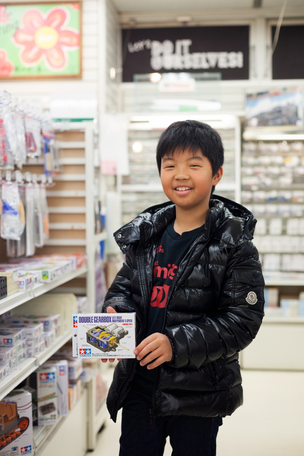 Young boy holding a toy train model in Tokyu Hands miniature models section.