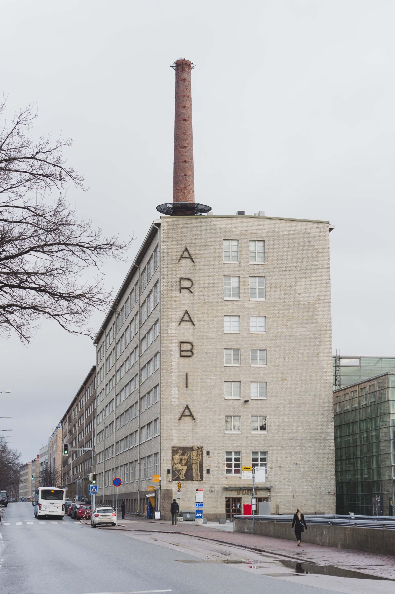 Brick building with tall chimney and vertical "ARABIA" lettering on its facade.