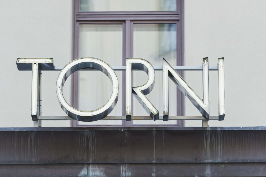 Chrome neon sign reading 'TORNI' mounted above a storefront window