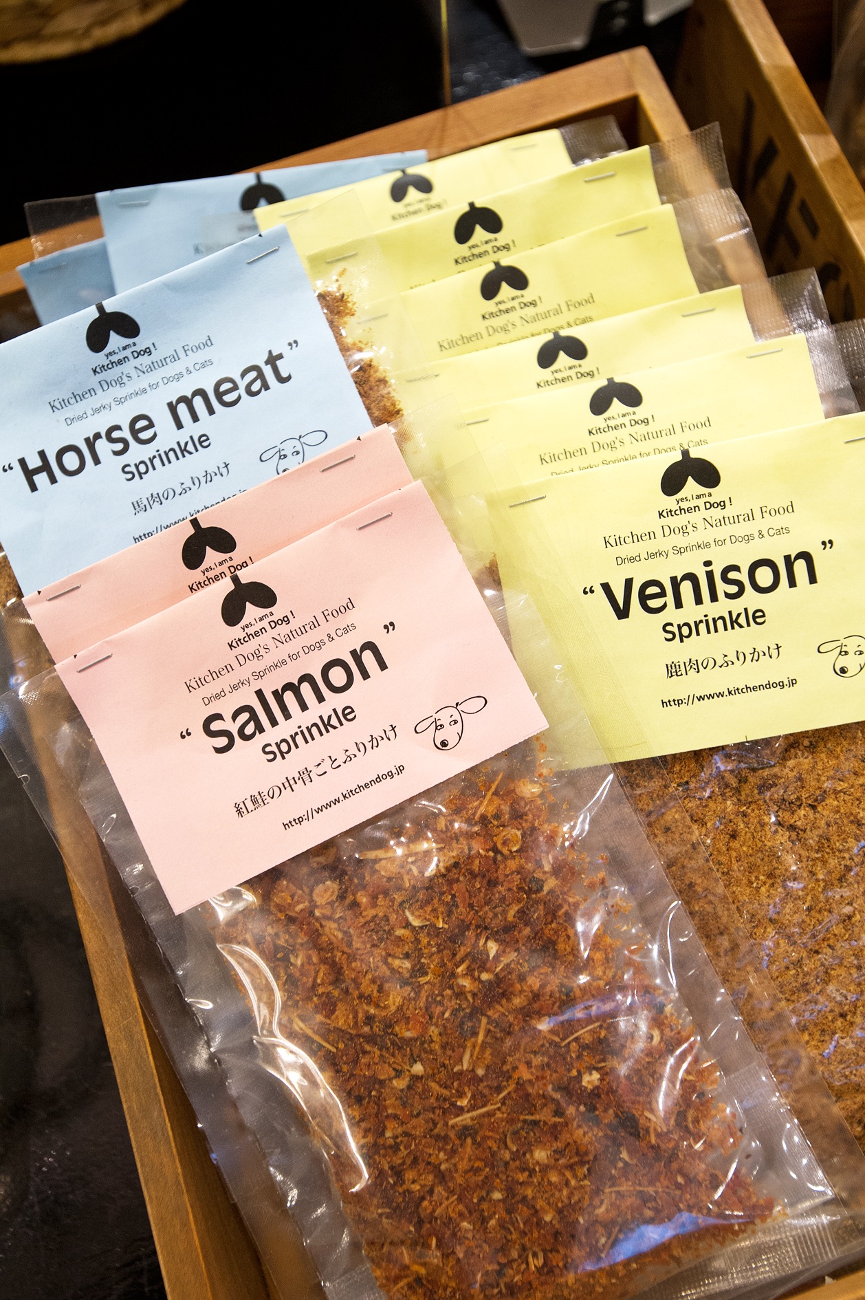Packaged dried meat sprinkles for dogs labeled Horse meat, Salmon, and Venison from Kitchen Dog!