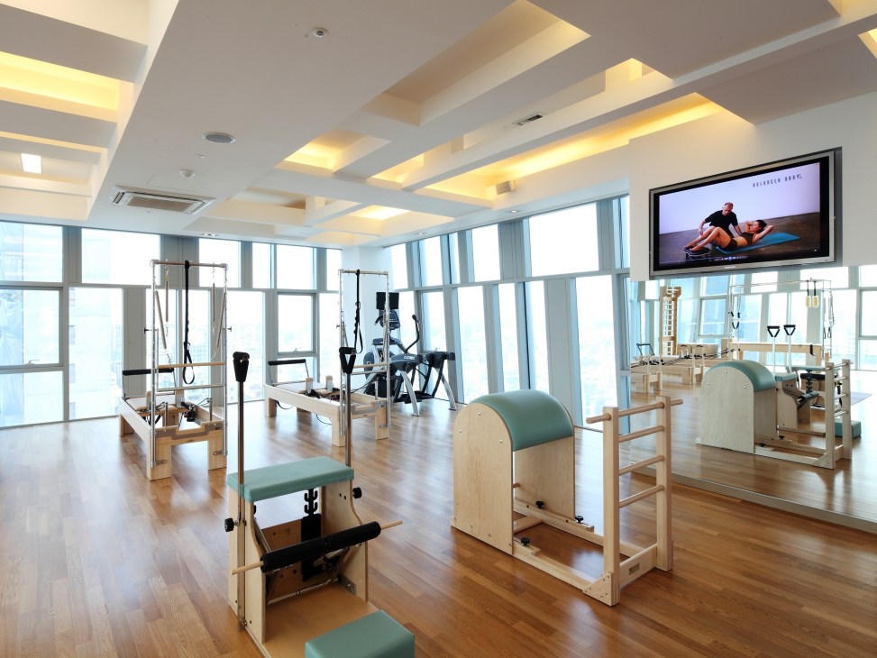 Interior of O-Pilates studio in Seoul with Balanced Body pilates equipment and large windows overlooking the city.