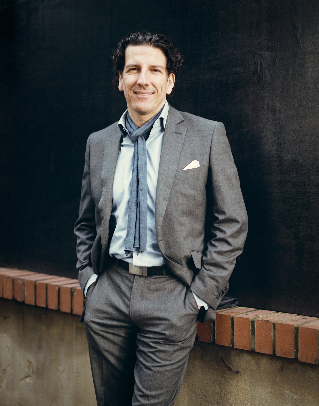 Santiago Matheus, co-founder and managing director of Method Design Lab, poses in a gray suit against a dark background.