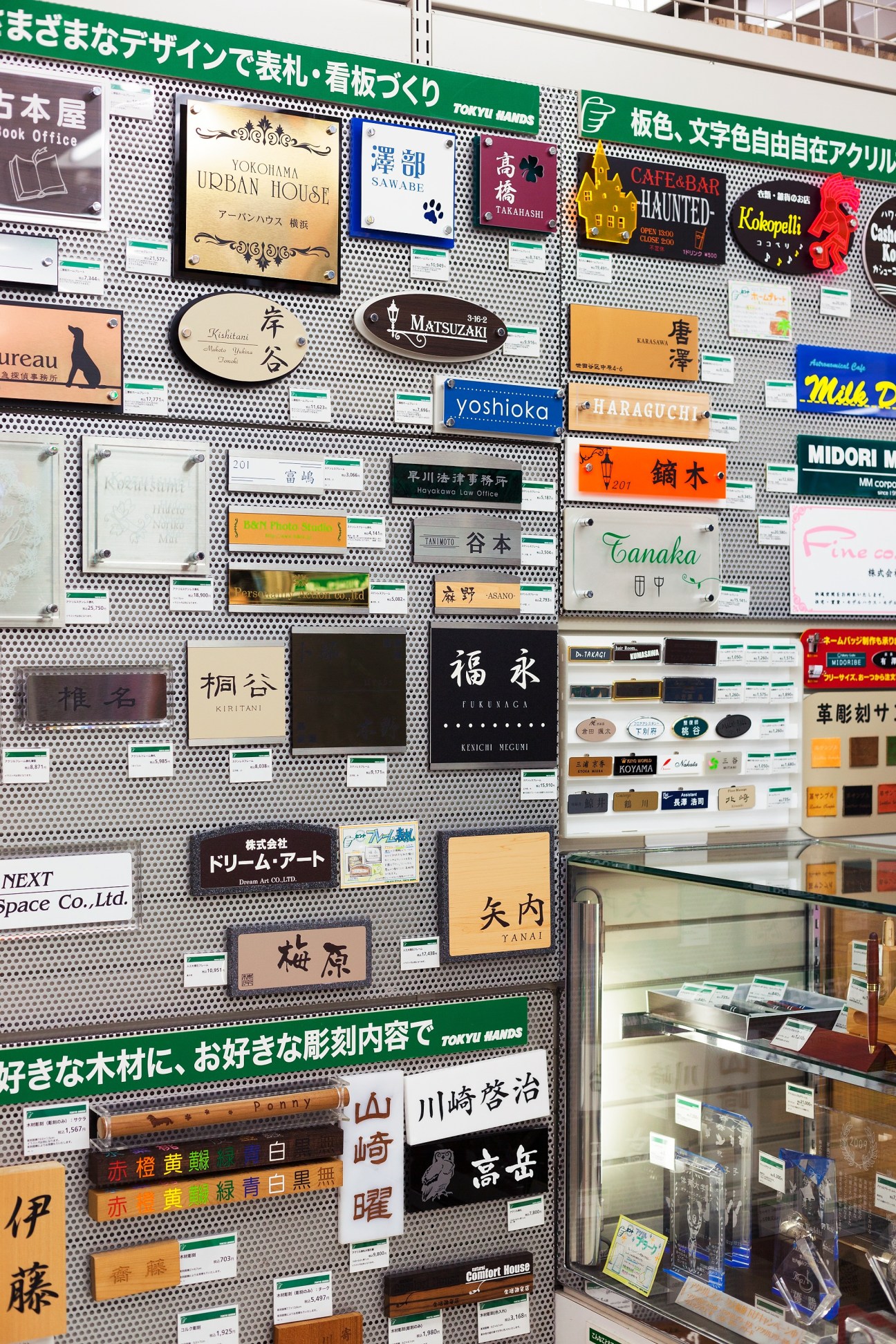 Display wall of custom-order name plates with various designs and Japanese characters at Tokyu Hands.