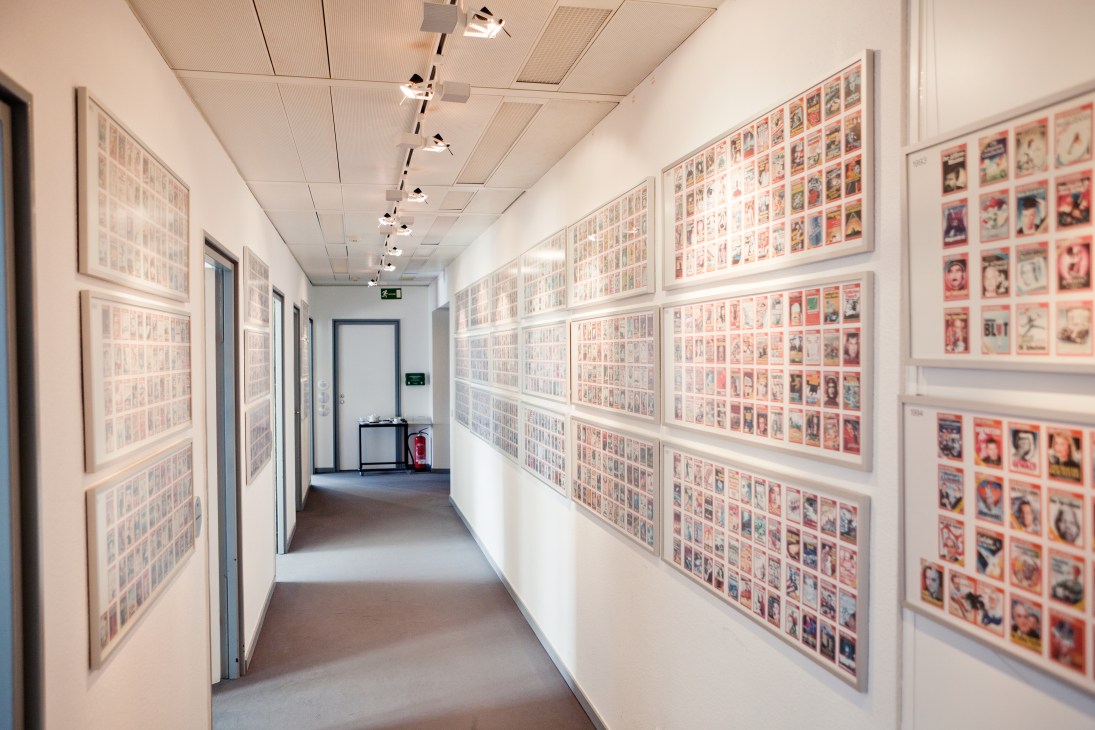 Hallway displaying framed Der Spiegel magazine covers spanning sixty years on white walls.
