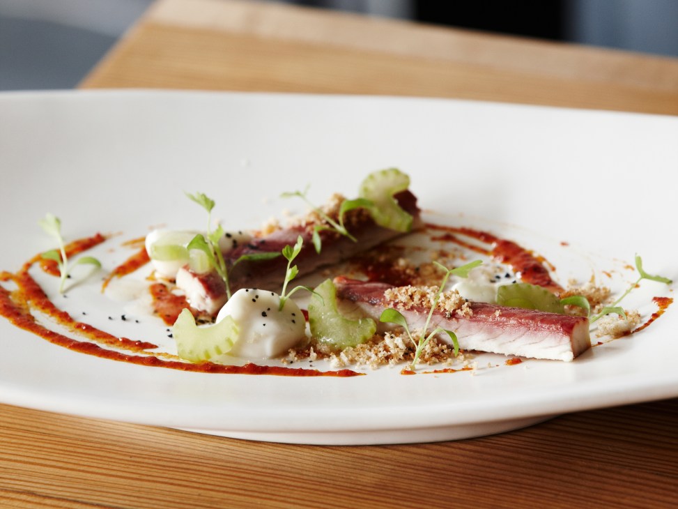Plated dish at Estelle Bar & Kitchen with seared tuna, microgreens, and garnishes on white plate.