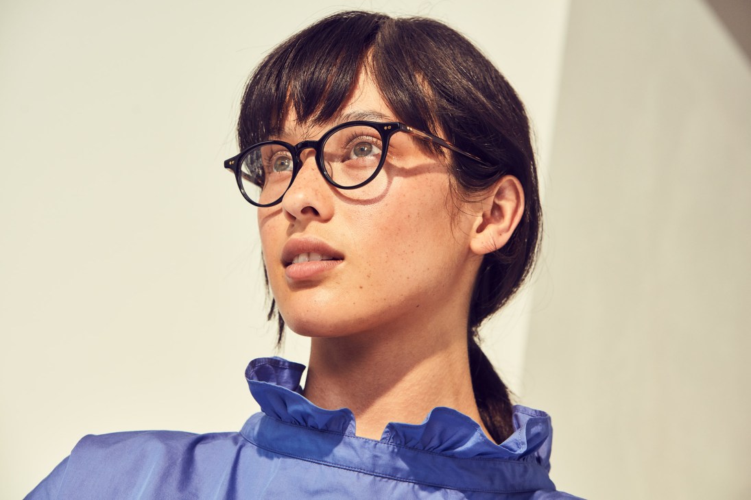 Woman wearing black-framed glasses by Kaneko Optical and a blue blouse by Atlantique Ascoli.