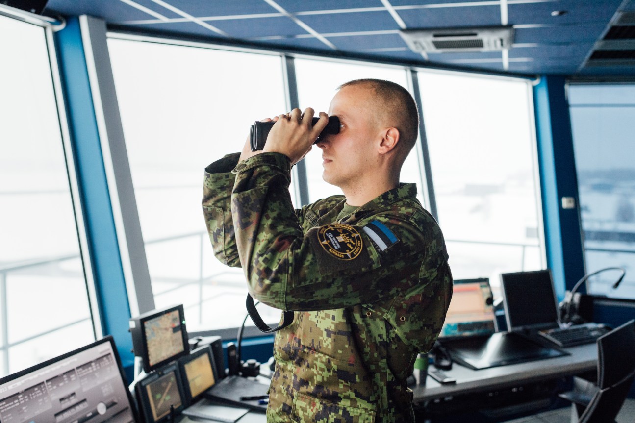 Air traffic controller using binoculars at Ämari airbase control tower