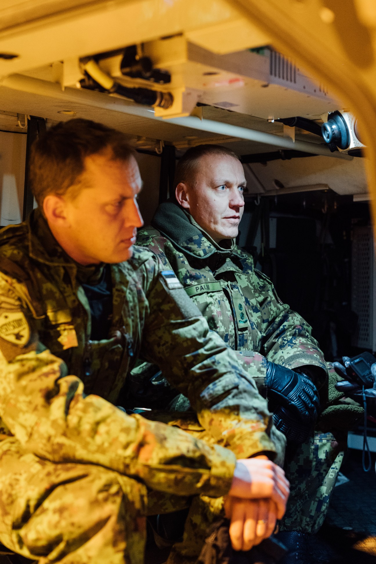 Commander Veiko-Vello Palm in camouflage uniform inside a military combat vehicle with yellow interior lighting.