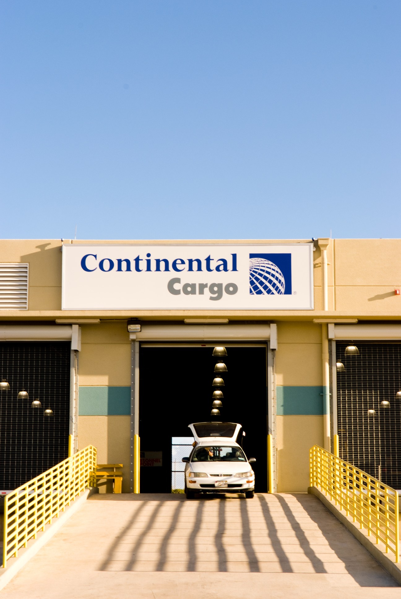 Continental Cargo facility with white vehicle parked in yellow and tan hangar doorway.