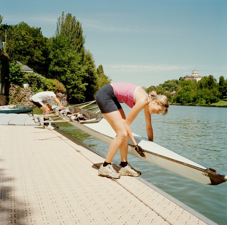 Rowers preparing rowing boats at a dock on the Parco del Valentino in Turin.