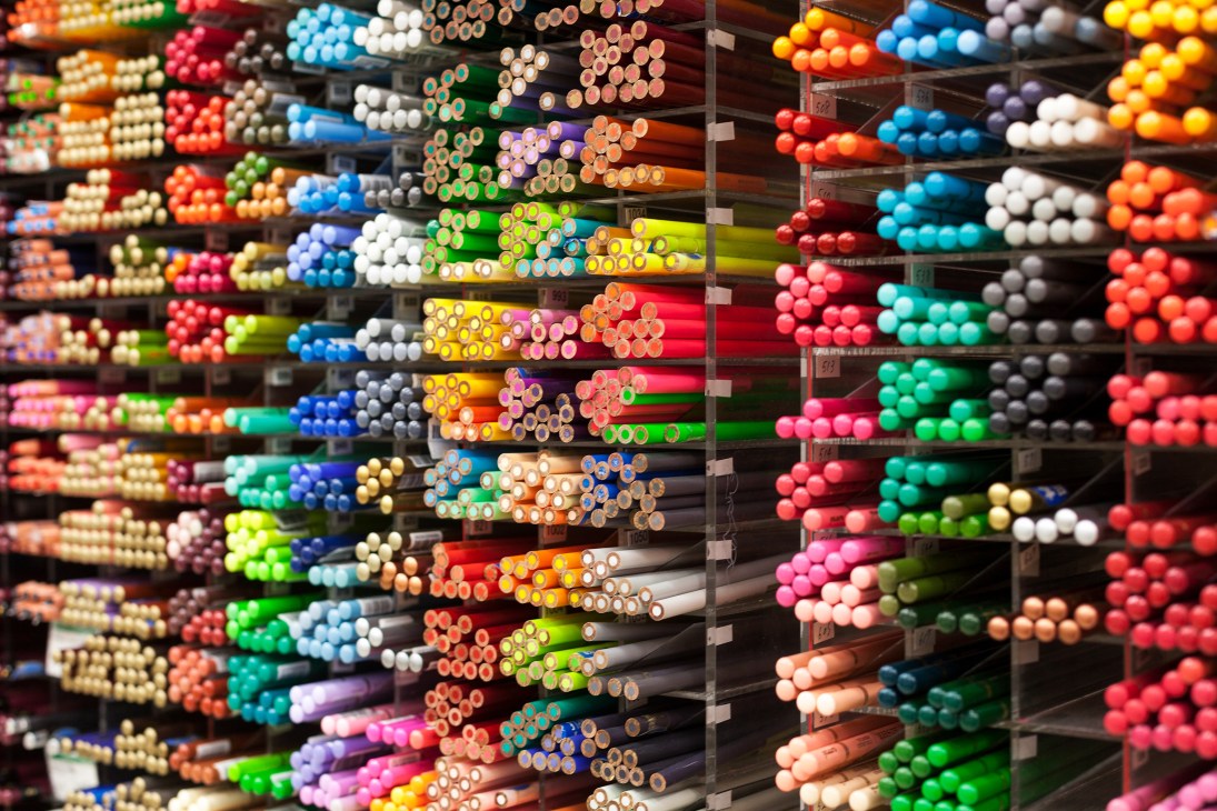 Shelves of multicolored pencils organized by color in Tokyu Hands store.