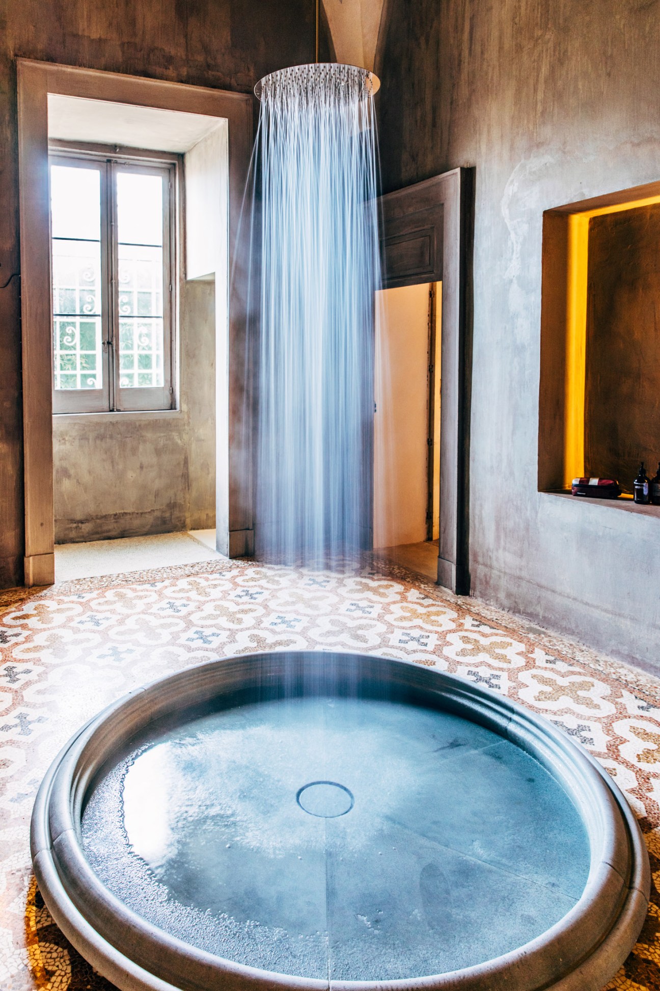 Shower designed by Andrea Sala with a dramatic rain showerhead and translucent curtain in a neoclassical palazzo bathroom.